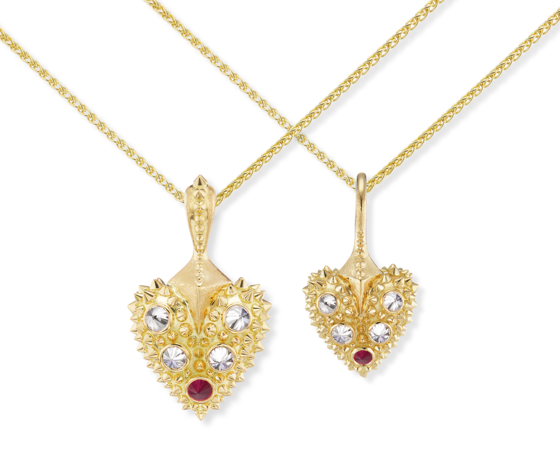 A closeup view of two 18k gold hearts with inverted diamonds & one ruby with 18k yellow gold spikes on 2mm yellow gold chains - designed by Ana-Katarina Fine Jewelry.