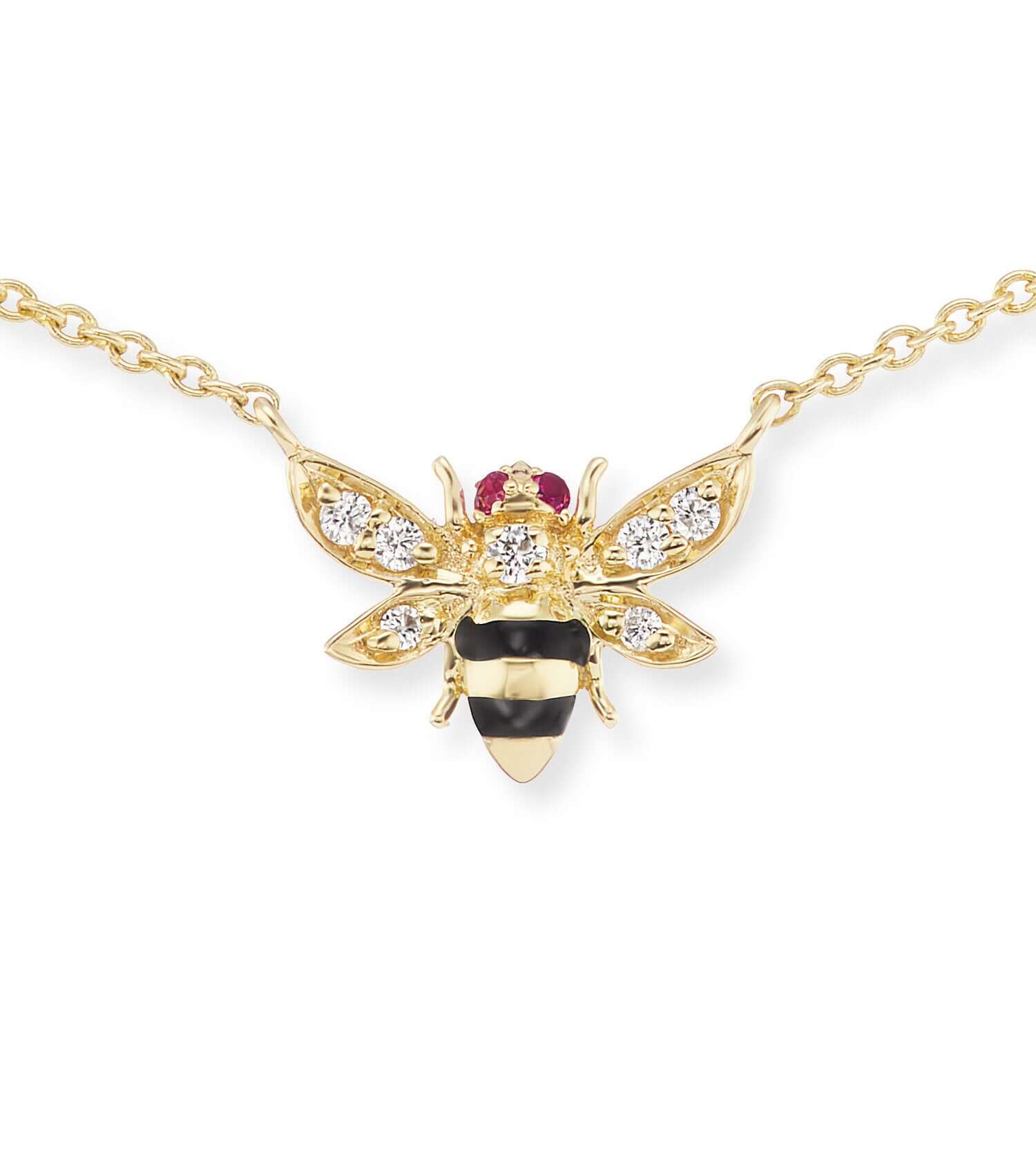 A closeup of a Bee Charm Necklace: expertly designed and crafted in 18k yellow gold with diamond wings, ruby eyes, and black enamel and gold stripes on a gold chain. Designed by Ana-Katarina Fine Jewelry.