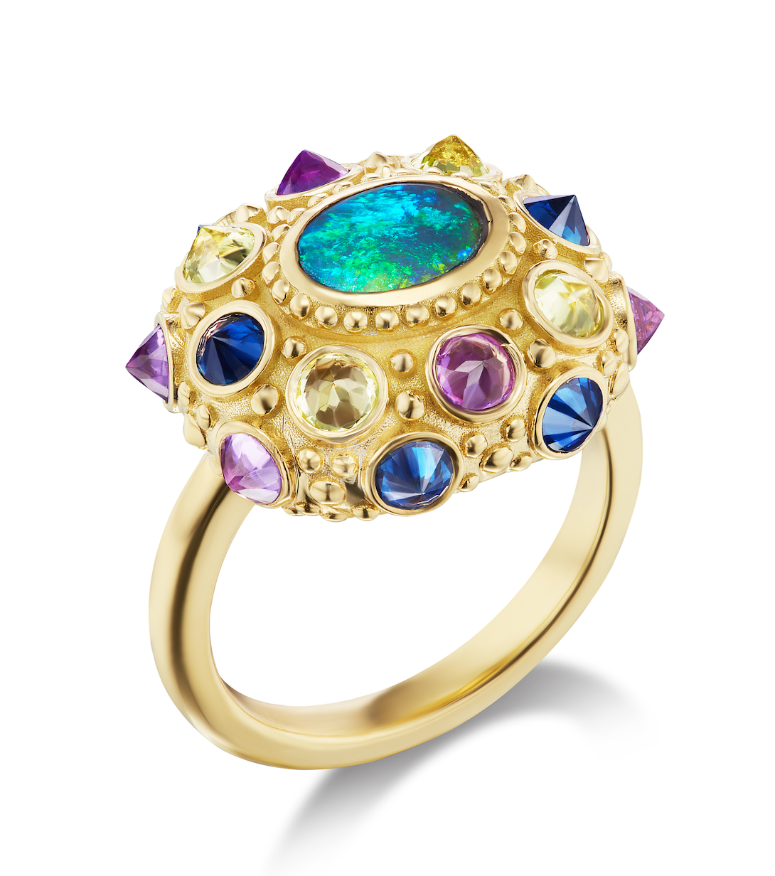 A side view of AnaKatarina's statement piece: the Blue Valentine Ring. Crafted from 18k yellow gold and adorned with a Lighting Ridge black opal and vibrant peridots, amethysts, and blue sapphires. With spiritual properties and an engraved 'LOVE', this ri