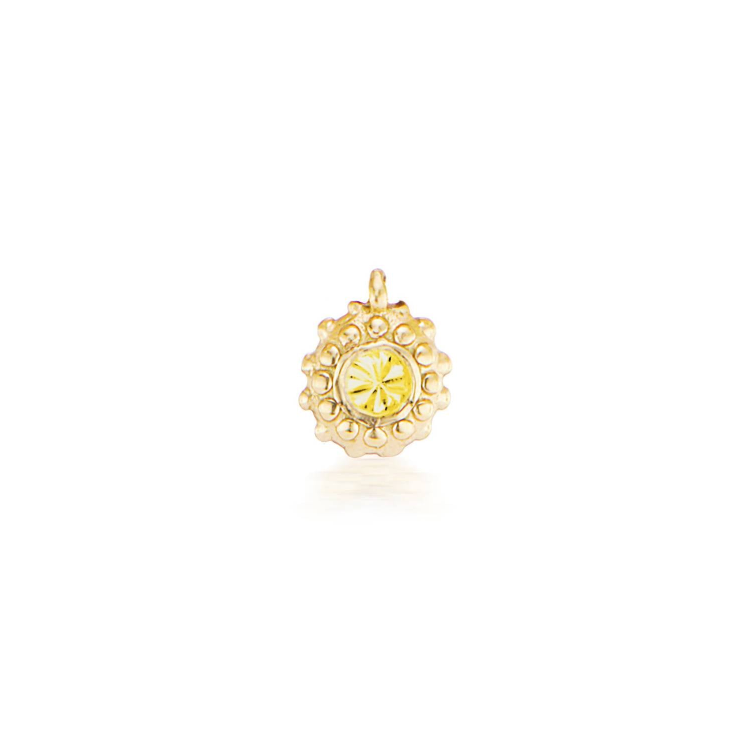 An 18k yellow gold circular charm with raised soft 'spikes' and an inverted yellow topaz for the November / Scorpio birthstone in the center.