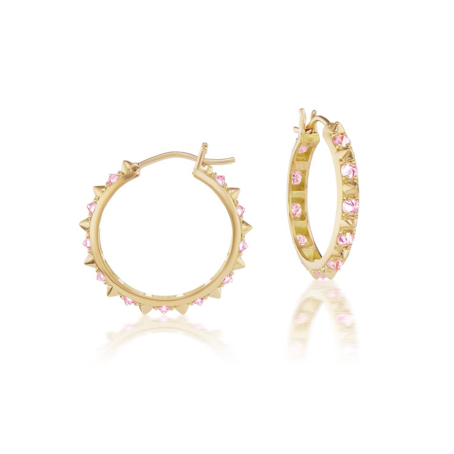 A side view of the opulent Large Valerie Pink Sapphire Hoops in pink and yellow, crafted with 18k yellow gold and adorned with inverted pink sapphire and gold spikes, they're a reinvented classic gold hoop earring.