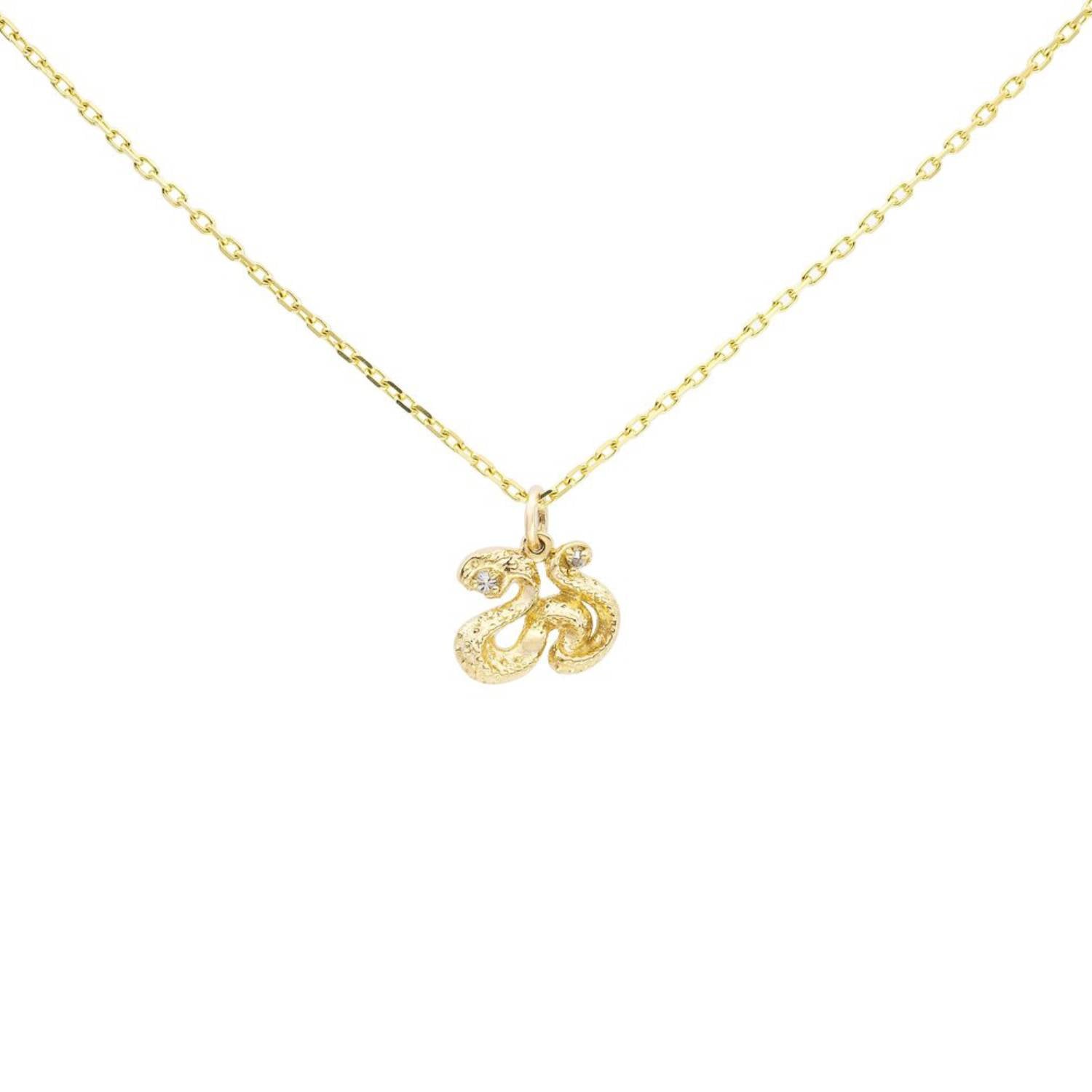 An an elegant diamond necklace featuring an 18k yellow gold serpent charm pendant with a diamond in its fangs on an 18-inch cable chain.