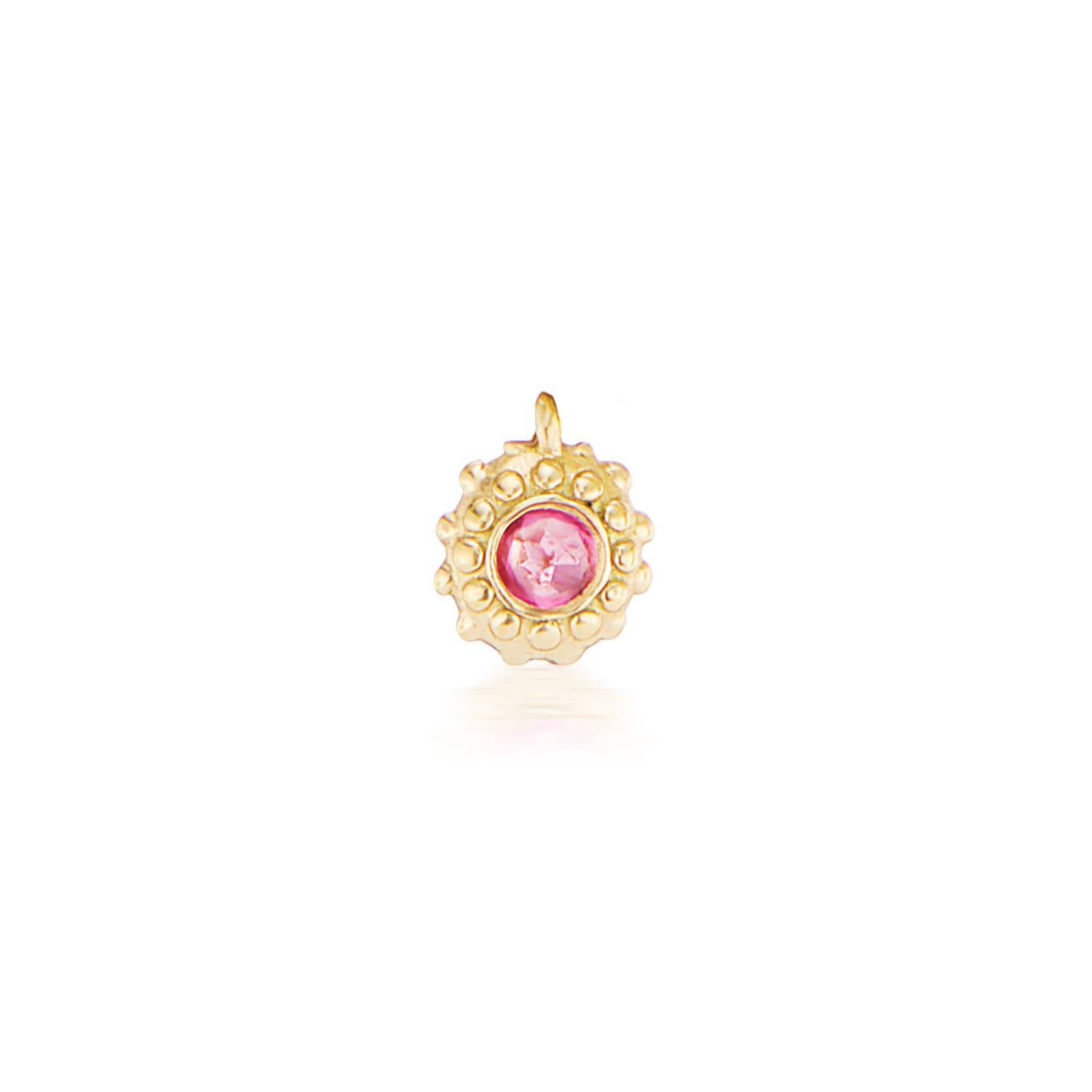 An 18k yellow gold circular charm with raised soft 'spikes' and an inverted pink tourmaline for the October / Libra birthstone in the center.