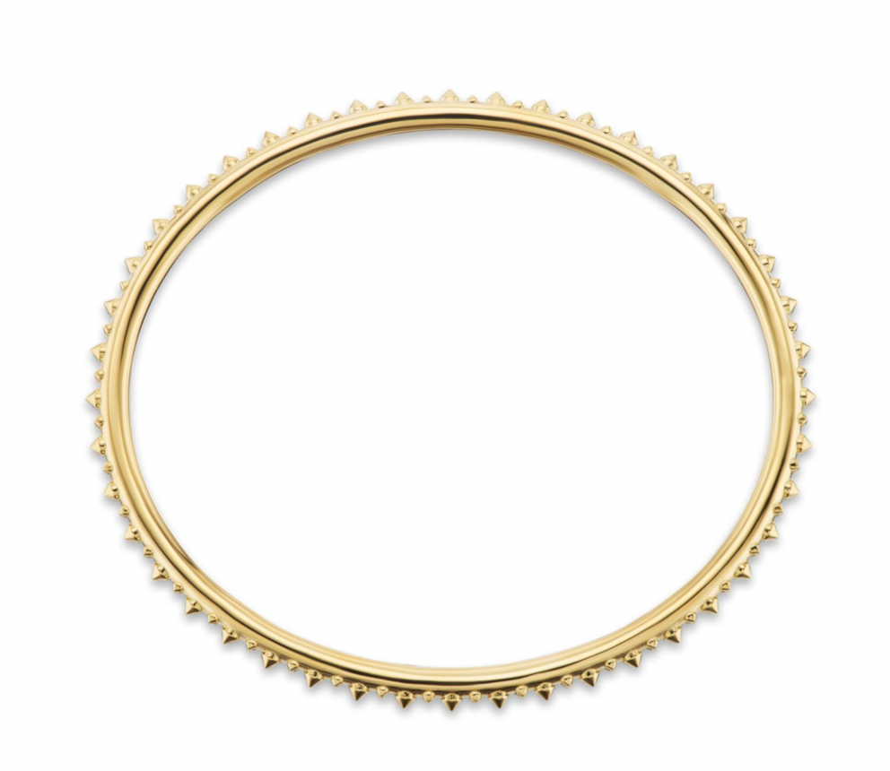 A full open view of AnaKatarina's Attitude Yellow Gold 'Adrina Loves a Bangle' 18K yellow gold bangle. In her reinvention of the classic bangle, AK combines traditional form with a fusion of confidence and femininity, showcasing luxurious 18k gold spikes