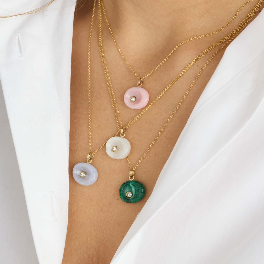 Model wearing AnaKatarina Pebble necklaces together, including the green Malachite Pebble diamond pendant.