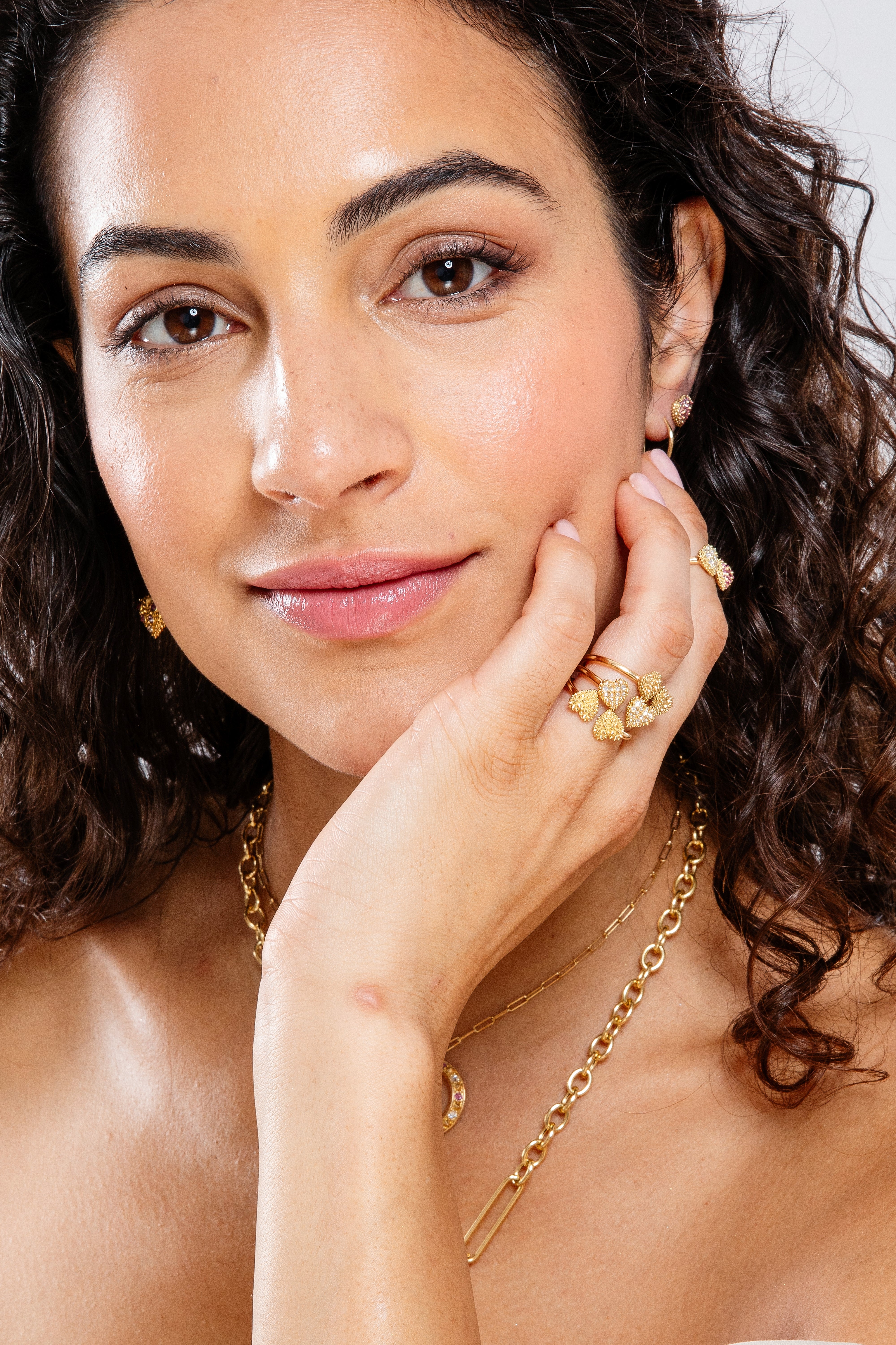 A person modeling how different variations of an 18k gold rings with two spiked hearts side by side for a new spin on the classic 'moi et toi' design by Ana-Katarina fine jewelry might be stacked for timeless luxury & style. 