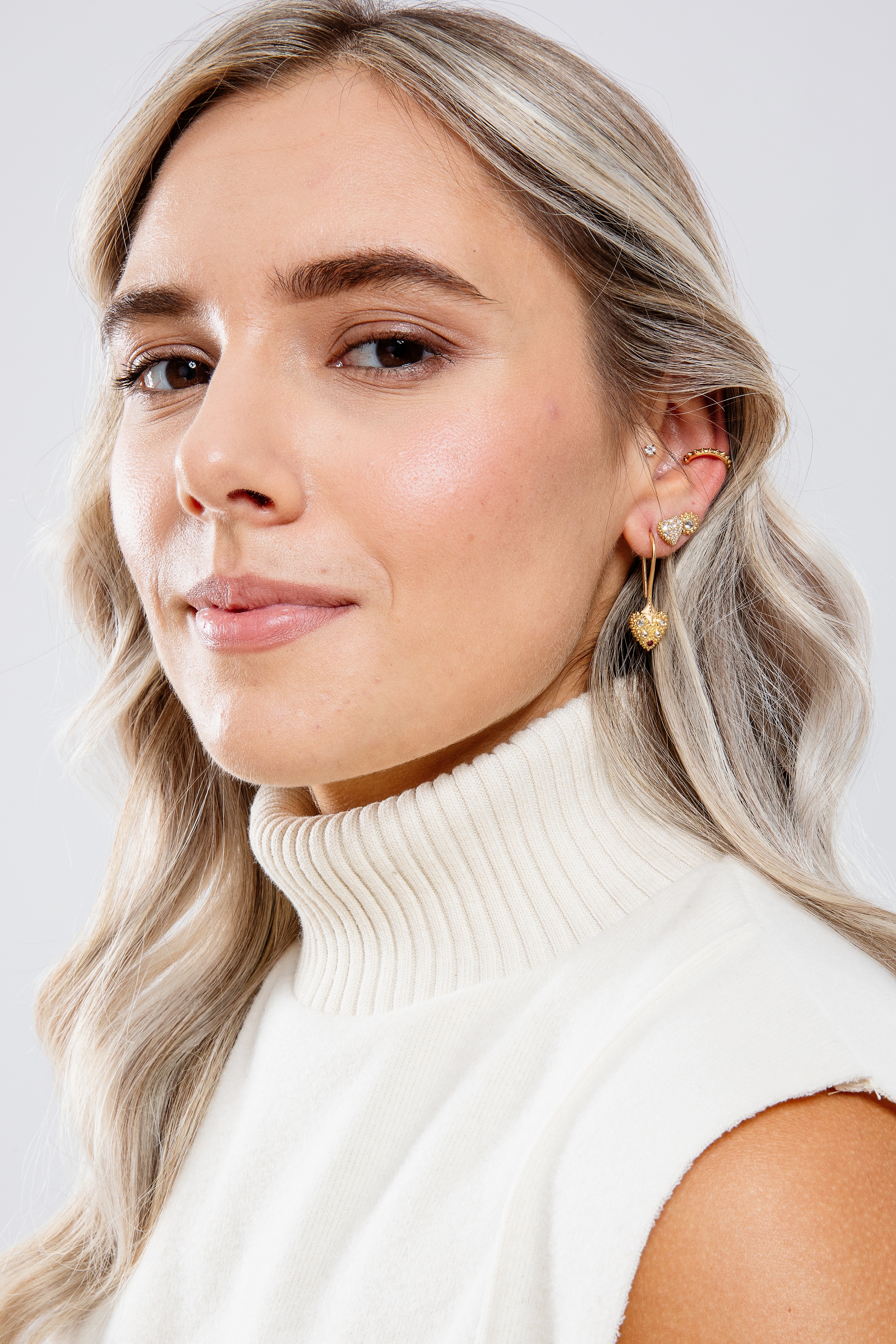 A model wearing various 18k yellow gold & inverted diamond spike drop & stud earrings from Ana-Katarina’s ‘Pierce Your Heart’ collection.