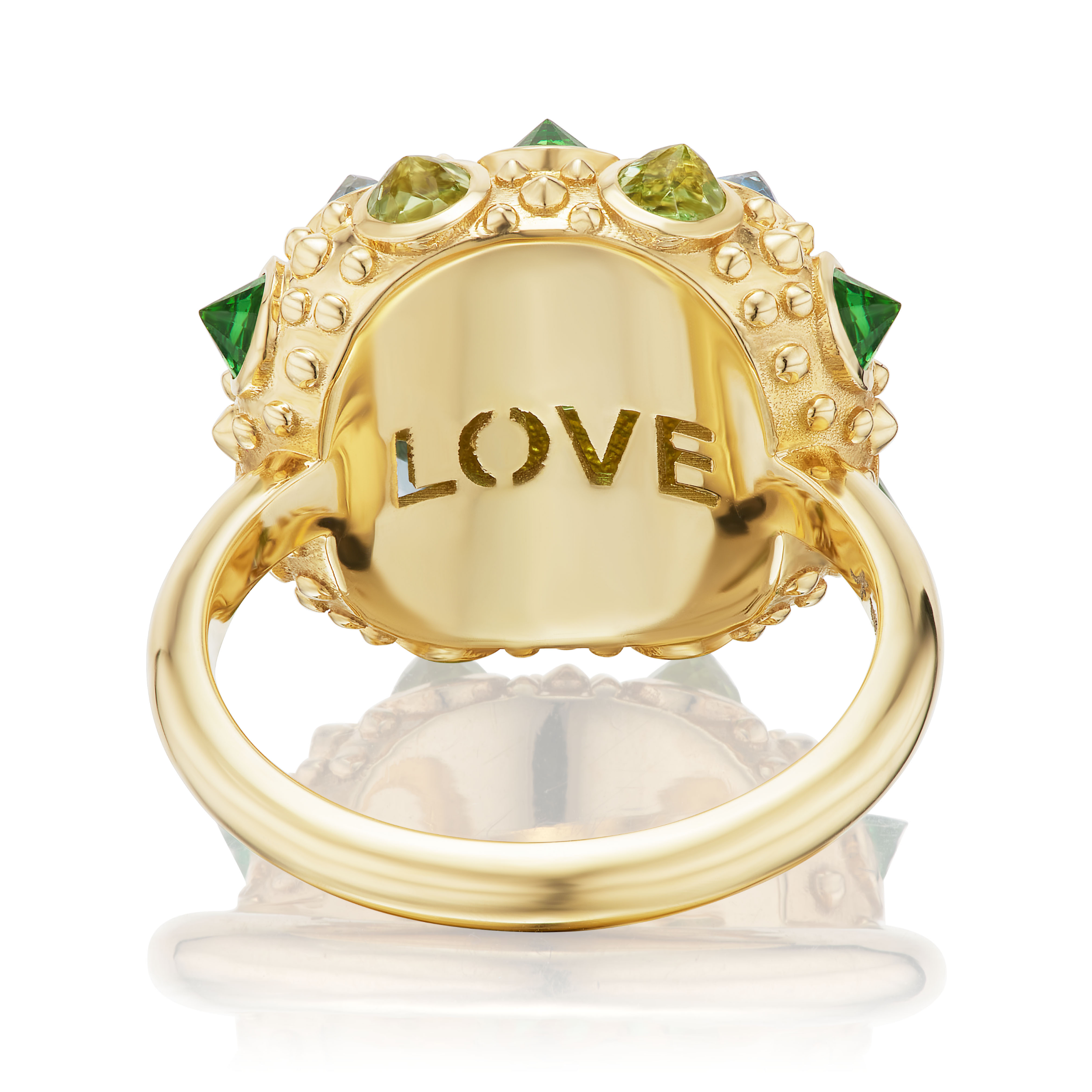 A view from the underside of an 18K Yellow Gold ring designed by AnaKatarina featuring the word "Love" carved out beneath a vibrant arrangement of Tsavorite Garnets, Aquamarines & Peridot in the colors of blue & green creating a captivating & colorful display.
