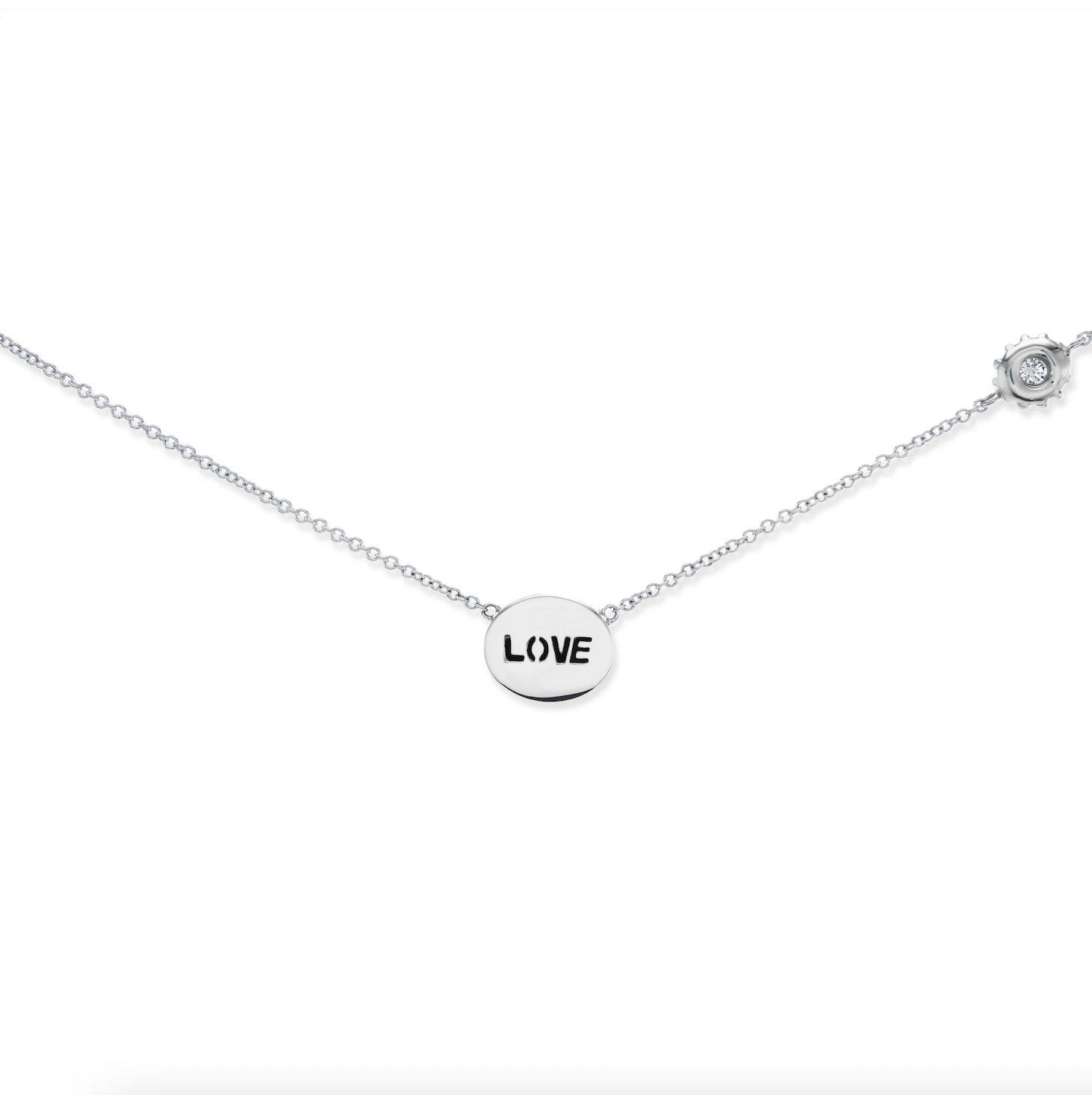 The reverse side of the ‘Eye Love’ Gold & Diamond Necklace in 18k white gold with an inverted diamond charm into which the word ‘love’ is carved. Designed & hand-crafted by Ana-Katarina Fine Jewelry.