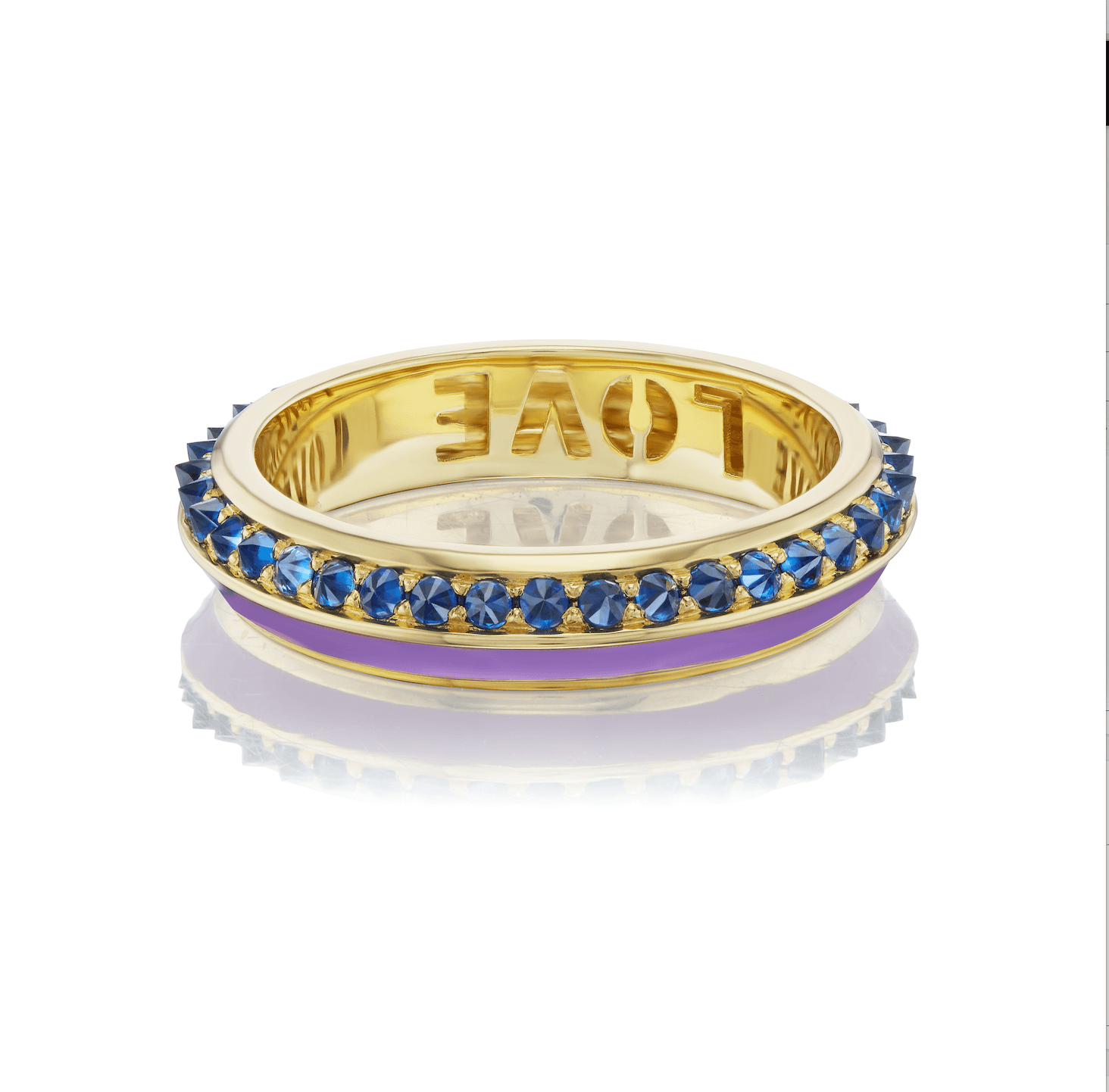 A side view of the 18K yellow gold 'Sweet, Happy Life' Blue Sapphire Stacking Ring designed by Ana-Katarina Fine Jewelry with .58 Blue Sapphires and smooth Lavender Enamel. The word "love" is inscribed on it. Perfect for stacking.