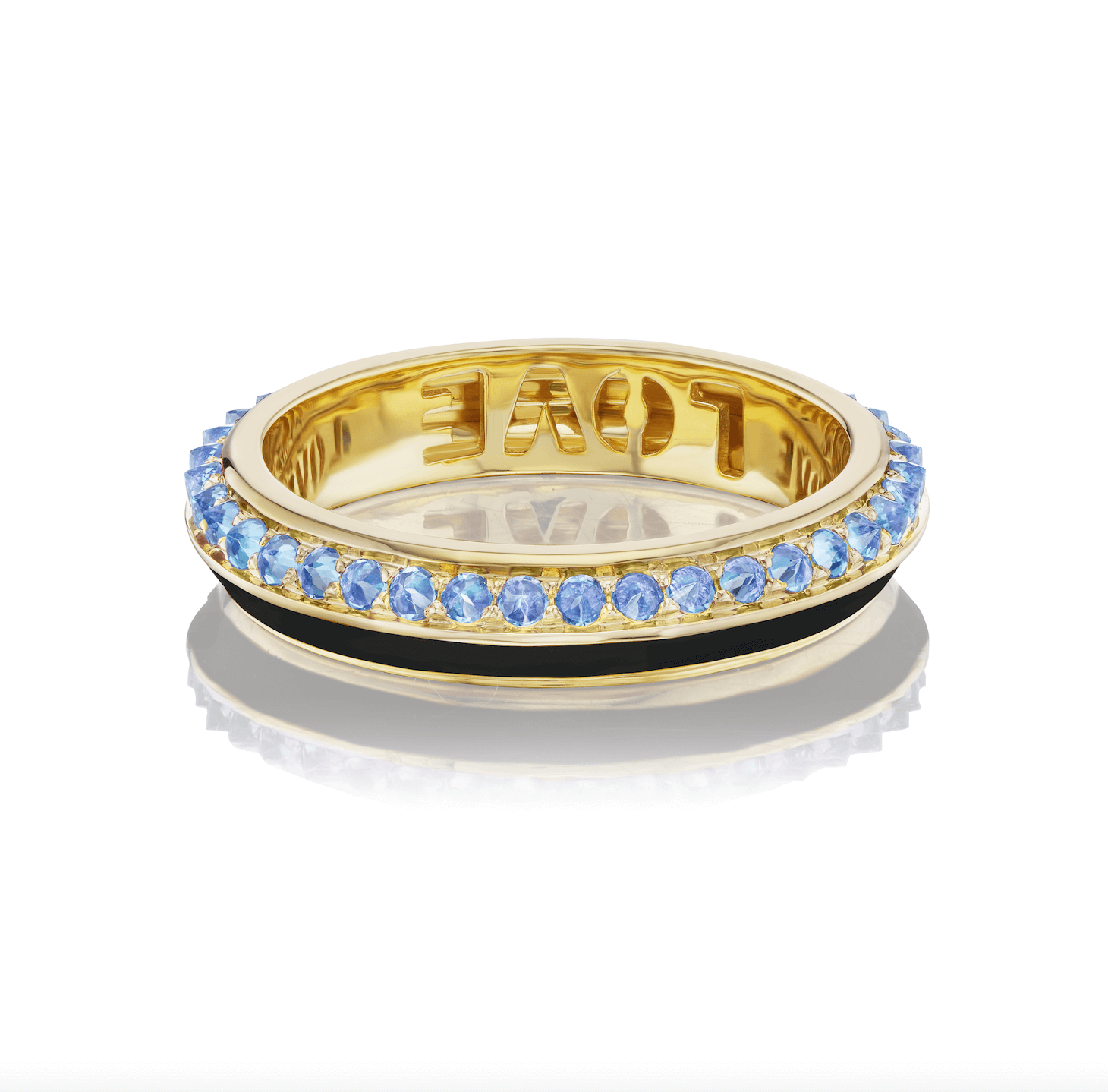 AnaKatarina's 'Sweet, Happy Life' Blue Topaz Stacking Ring lying on its side against a white background. This elegant ring features a combination of 18k yellow gold and black enamel, complemented by sparkling .48tw Blue Topaz stones, and engraved with the