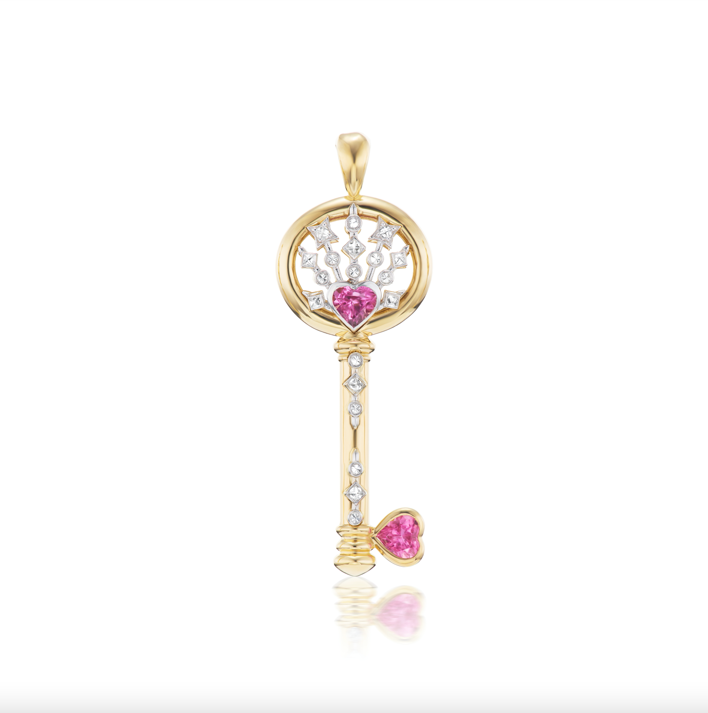 A closeup of AK's Impeccable Words: 'Love' Key Pendant in 18k yellow gold with two pink tourmaline hearts and diamonds against a white background. 