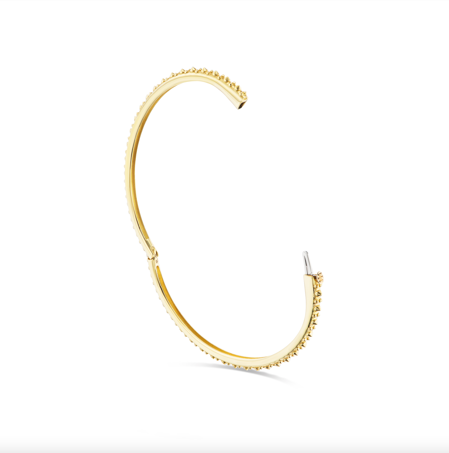 An open view of AnaKatarina's Attitude Yellow Gold 'Adrina Loves a Bangle' 18K yellow gold bangle. In her reinvention of the classic bangle, AK combines traditional form with a fusion of confidence and femininity, showcasing luxurious 18k gold spikes.