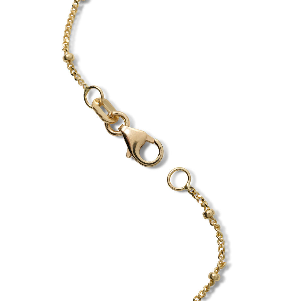 AnaKatarina Saturn chain with delicate gold links, evenly spaced polished gold beads, and a spring-ring clasp on a white background.