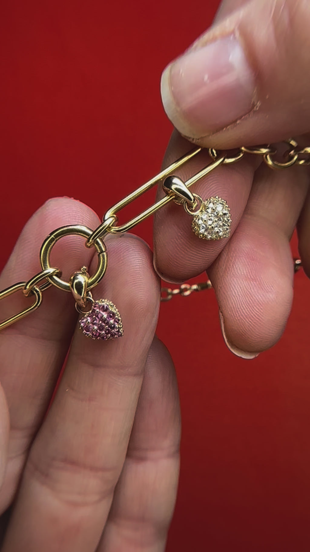 A video showing the ‘Pierce Your Heart’ diamond heart charmlette pendant on an 18k gold chain with one of the other charmlettes designed by Ana-Katrina Fine Jewelry. 