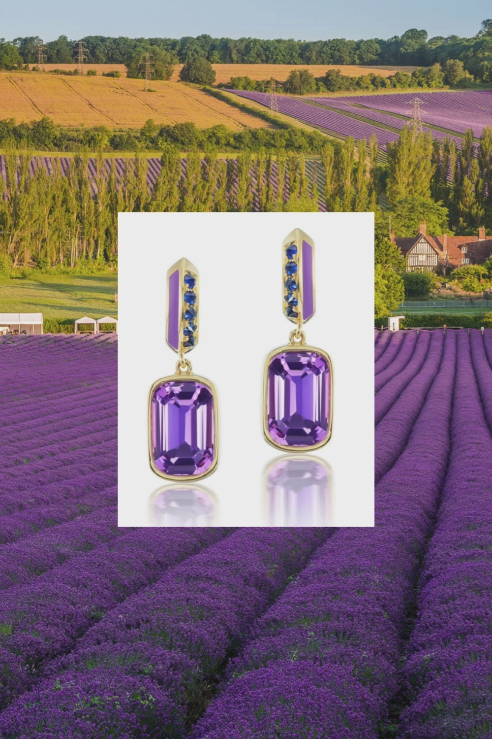 A pair of exquisite drop earrings designed by Ana-Katarina Fine Jewelry in opulent purple and blue hues, featuring .62-carat blue sapphires, a 5.3-carat amethyst drop, lavish lavender enamel, and 18k yellow gold on a background that features a French lavender field. 