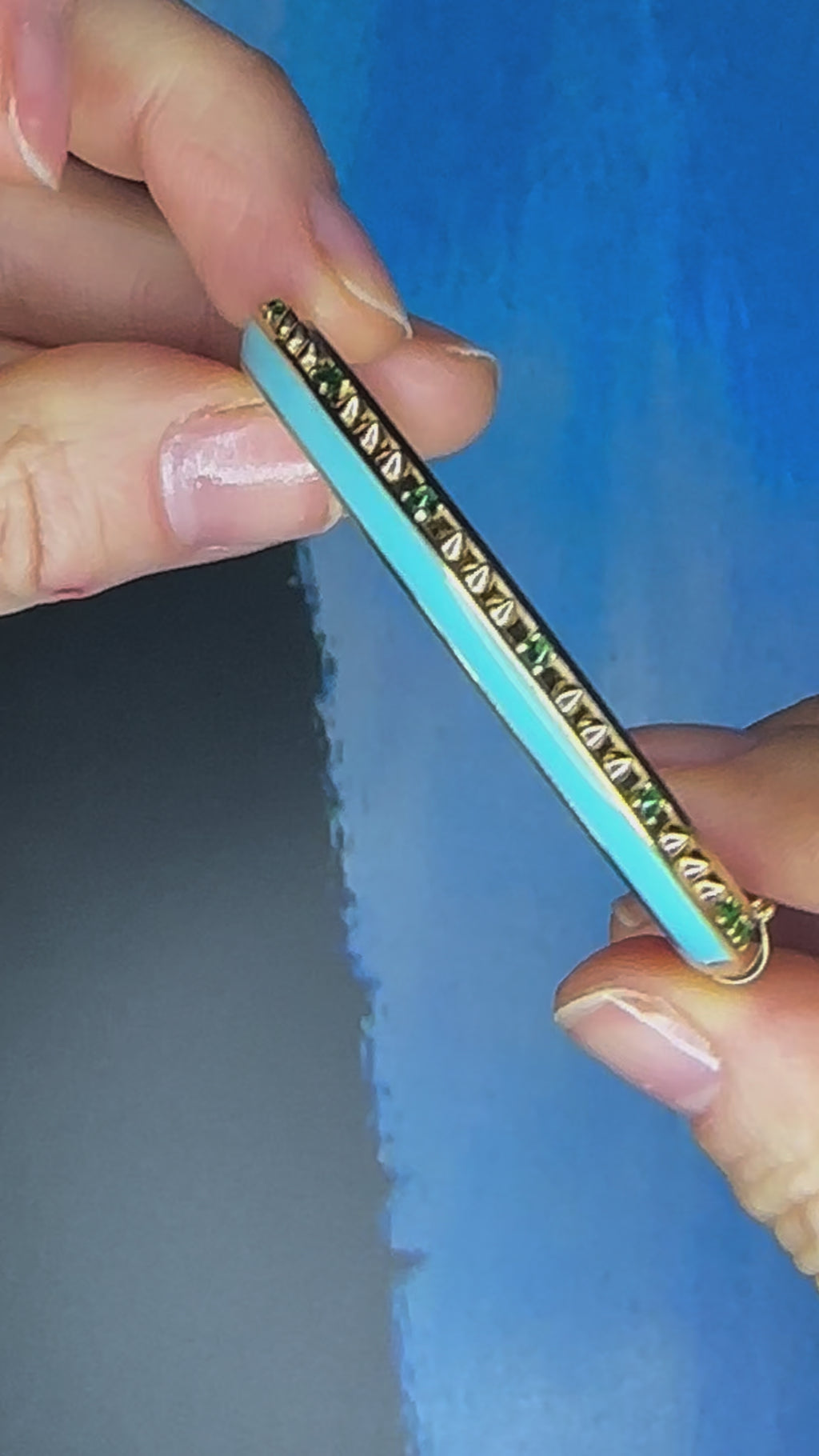 A video of the 'Sweet, Happy Life' Tsavorite Garnet stacking bangle designed by AnaKatarina Fine Jewelry featuring the words "love" in gold enamel, crafted from 18k Yellow Gold and embellished with .48tw Tsavorite Garnet and Turquoise Enamel.