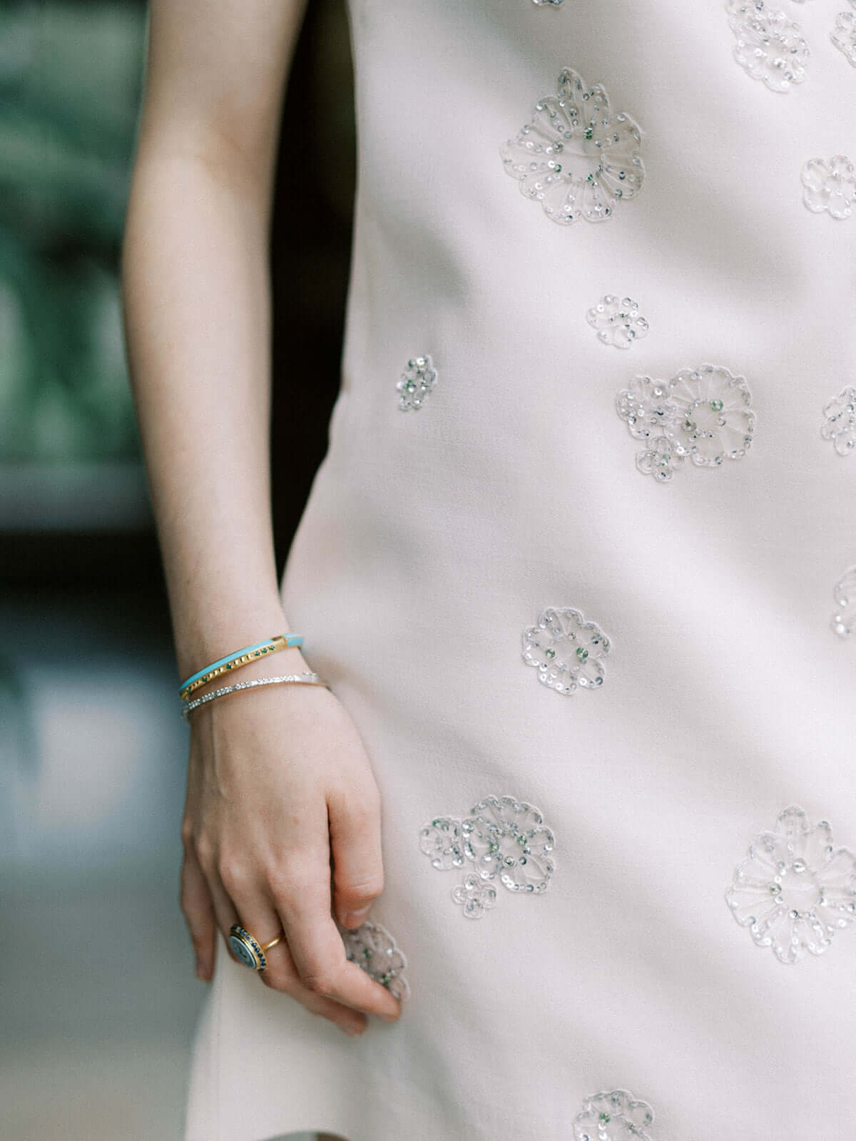 A person wearing the 'Sweet, Happy Life' Tsavorite Garnet stacking bangle designed by Ana-Katarina Fine Jewelry, crafted from 18k Yellow Gold and embellished with .48tw Tsavorite Garnets. 
