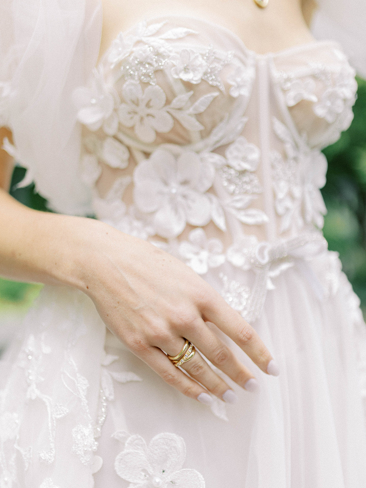 A model in a wedding gown with her hand at her waist showcasing Ana-Katarina's ‘Amy's Attitude Diamond Ring,’ showcasing elegant, interwoven 18k yellow gold bands embellished with inverted diamonds for a touch of opulence & bold luxury.