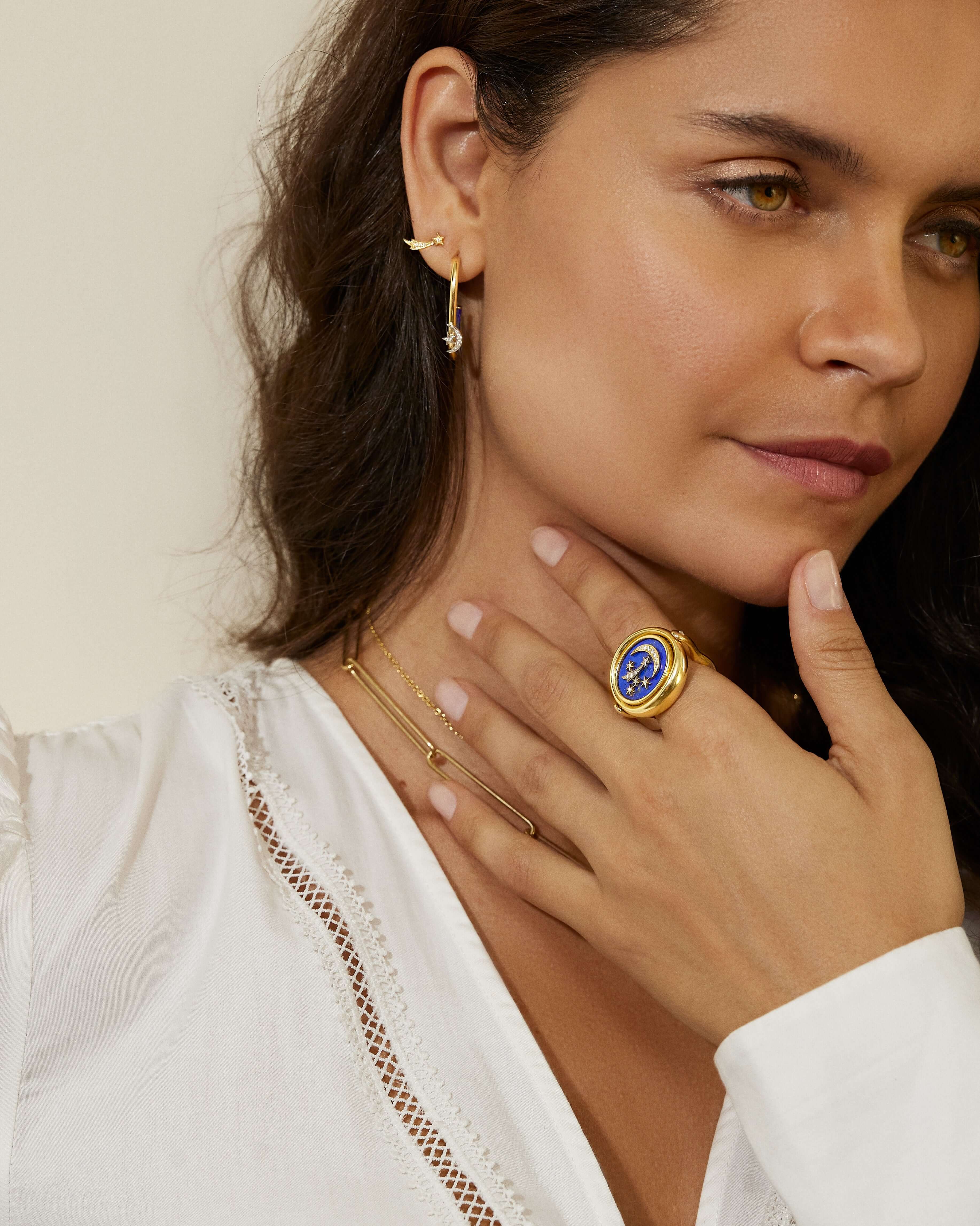 A person modeling Ana-Katarina's 4 Elements Air Flip Ring in 18k gold, diamonds, and blue enamel featuring the moon and shooting stars. 