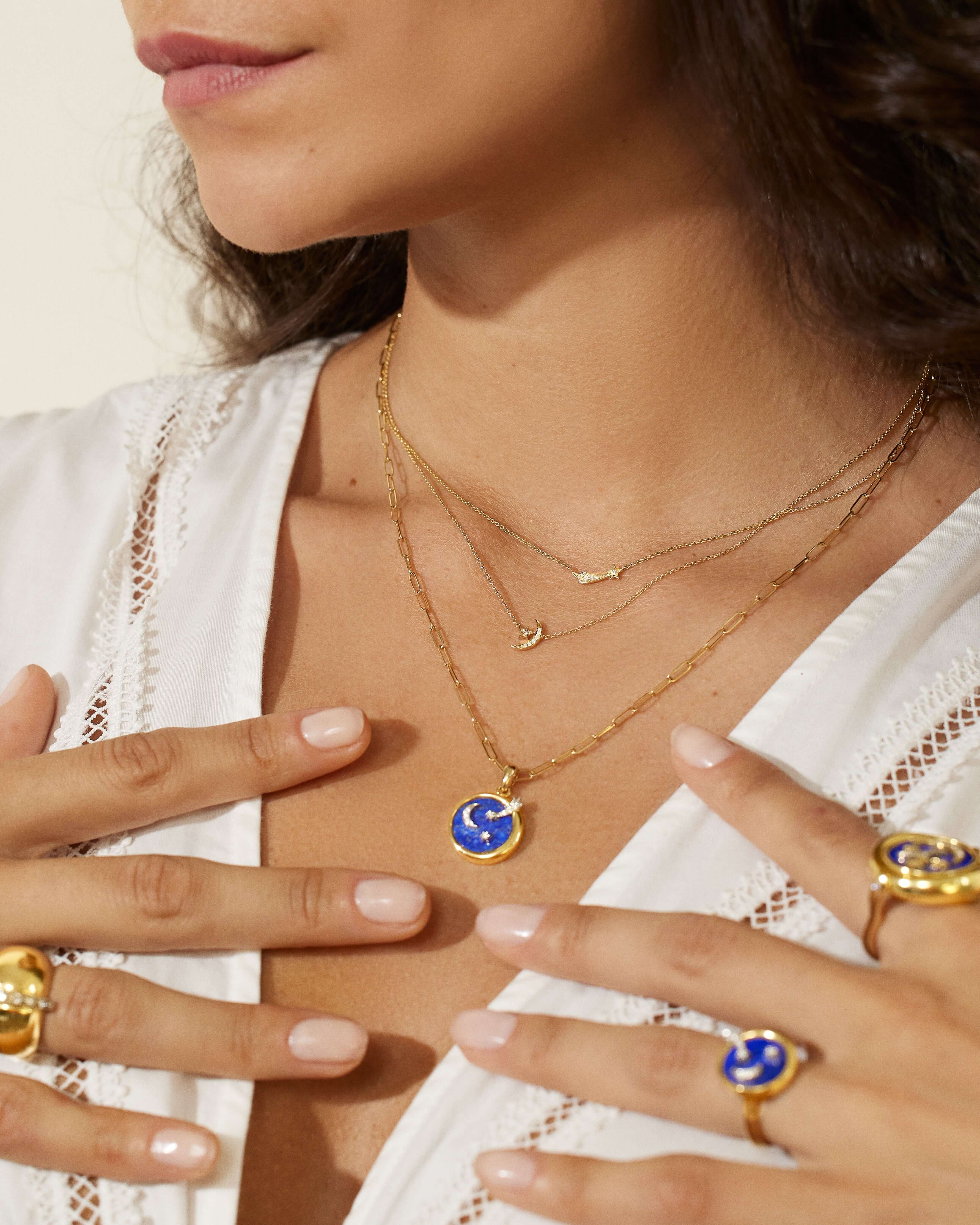 A person modeling Ana-Katarina's 4 Elements Air Pendant. The necklace is an 18k Yellow Gold, Chilean Lapis & .049ct Diamond pendant on an 18" 18k gold Baby Rectangle Chain.