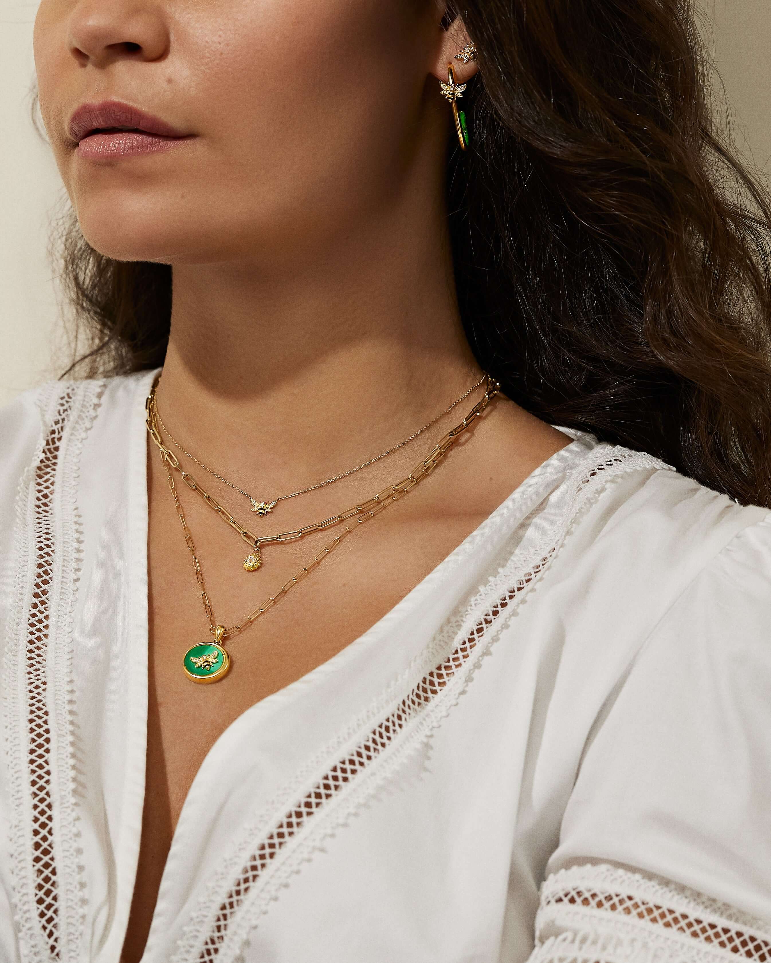 A model wearing three small gold necklaces from Ana-Katarina’s ‘4 Elements’ collection, as well as stud earrings from Ana-Katarina fine jewelry. 