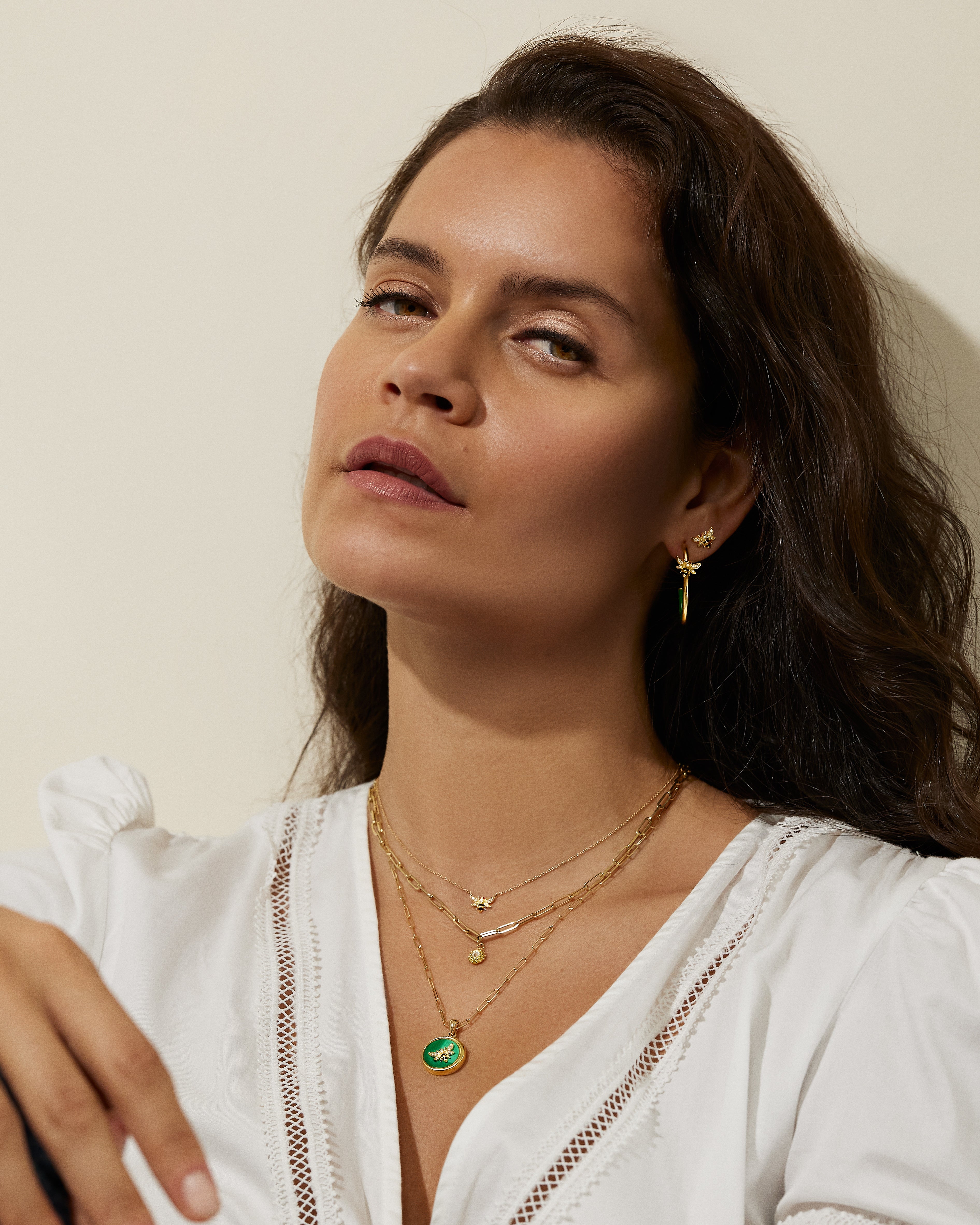 A model wearing five pieces of Ana-Katarina fine 18k yellow gold jewelry - one of which is the 4 Elements Bee Stud Earrings. 