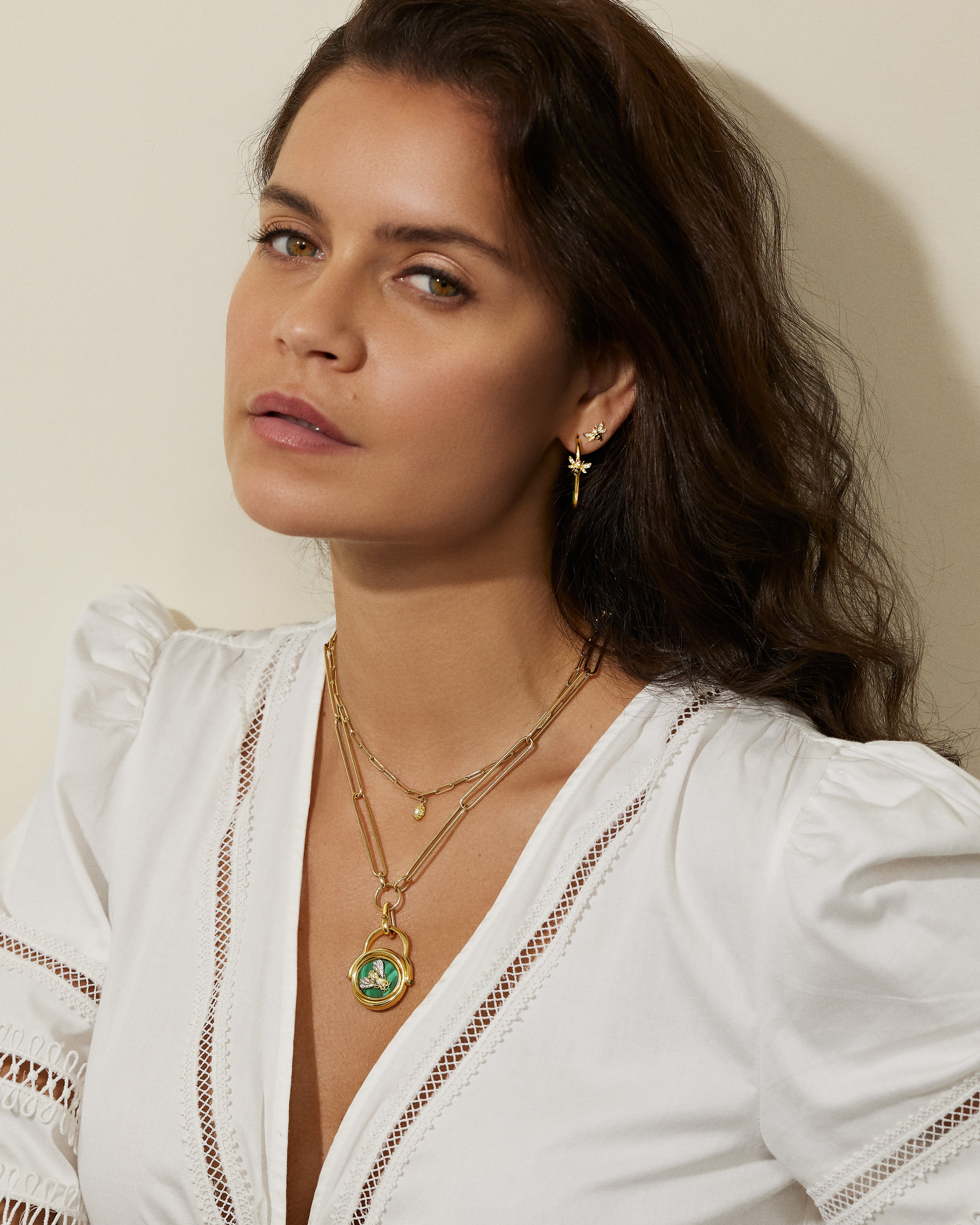 A model wearing various diamond necklaces and earrings in 18k yellow gold designed by Ana-Katarina Fine Jewelry. 