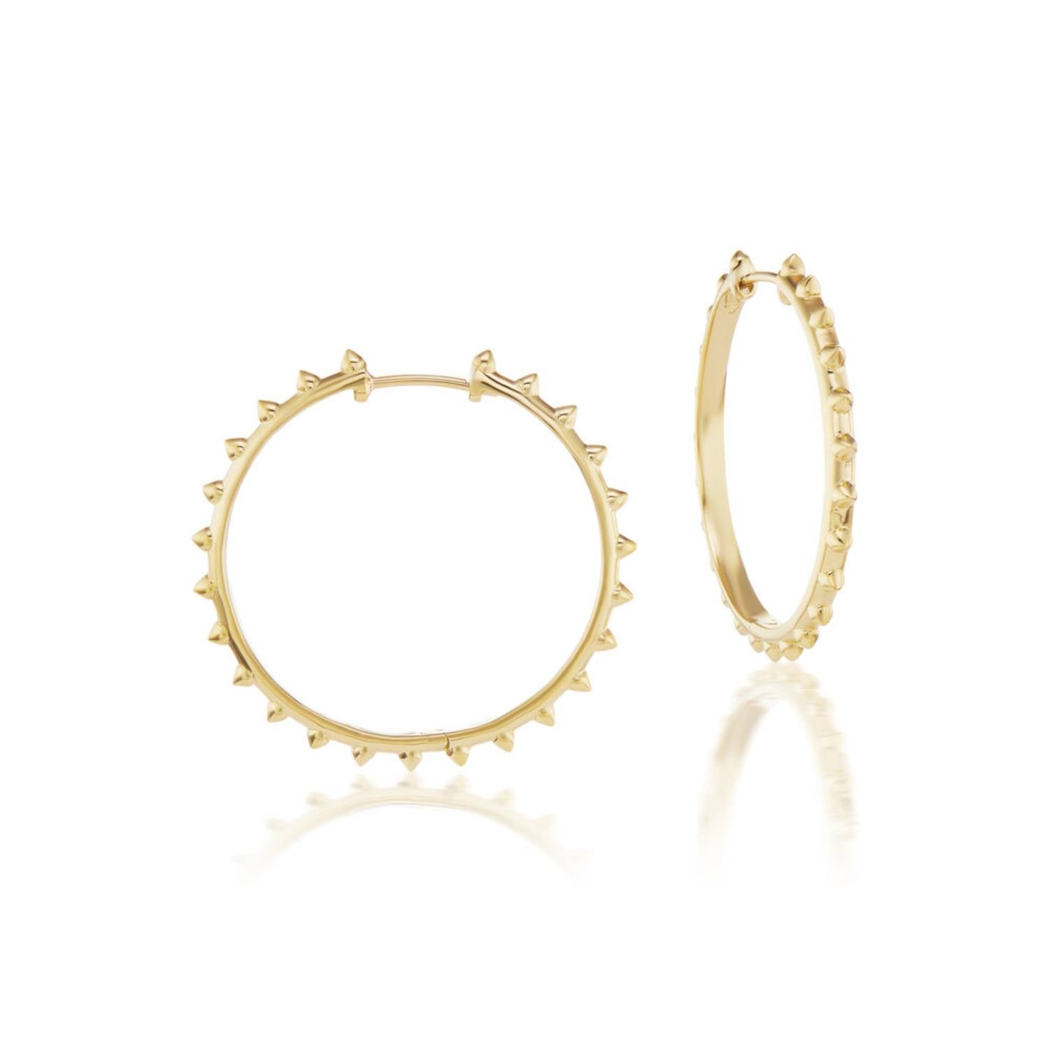A front & side view of the stunning 'Adrina Loves a Hoop' large 18k yellow gold hoop earrings with soft spikes from the AnaKatarina 'Attitude' Collection against a white background. Designed by Ana-Katarina Fine Jewelry. 