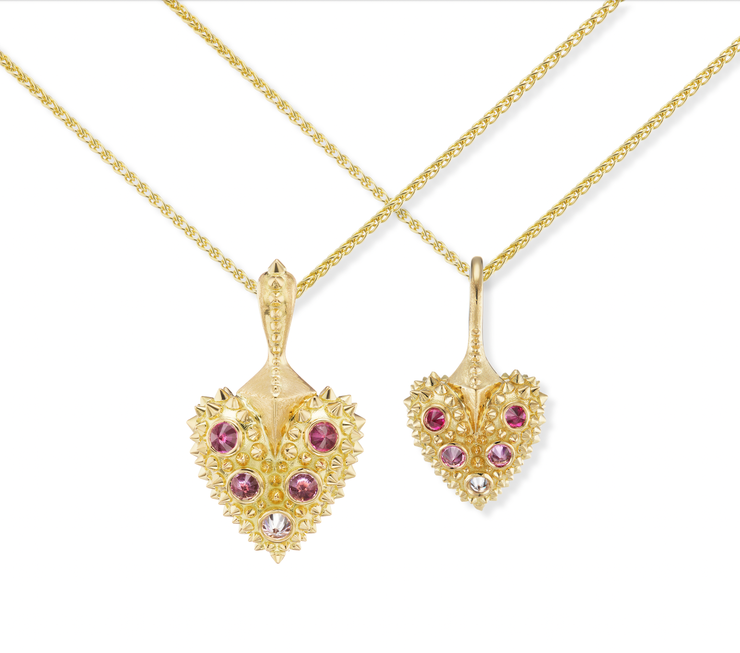 A model wearing Ana-Katarina’s 18k yellow gold heart necklace with the pink sapphire spike heart necklace - both from the ‘Pierce Your Heart’ collection - both on varying lengths of 18k yellow gold cable chains. 