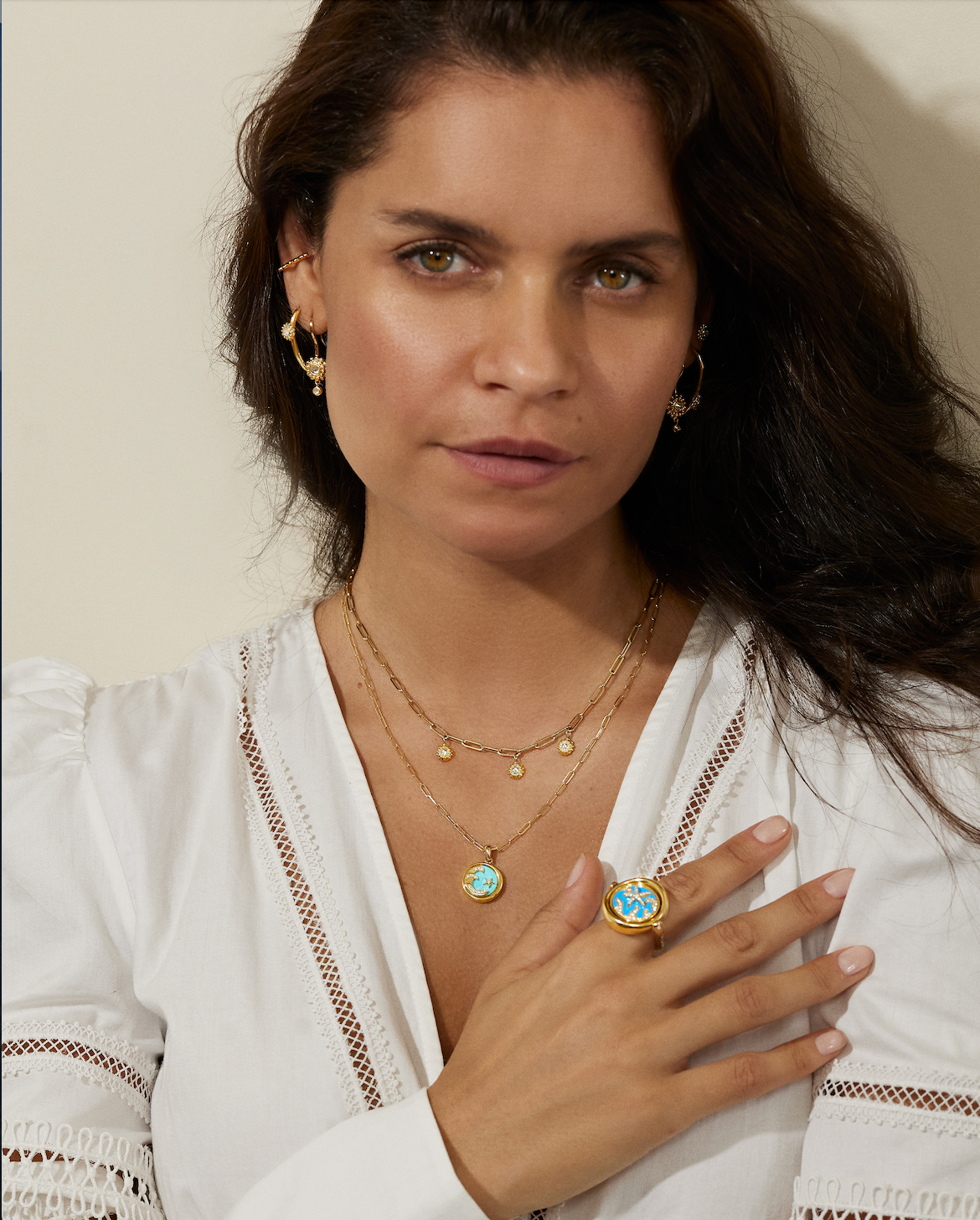 A model wearing various unique pieces of fine jewelry - 18k yellow gold and diamond necklaces, hoop earrings, stud earrings, and ear cuffs designed by Ana-Katarina Fine Jewelry. 