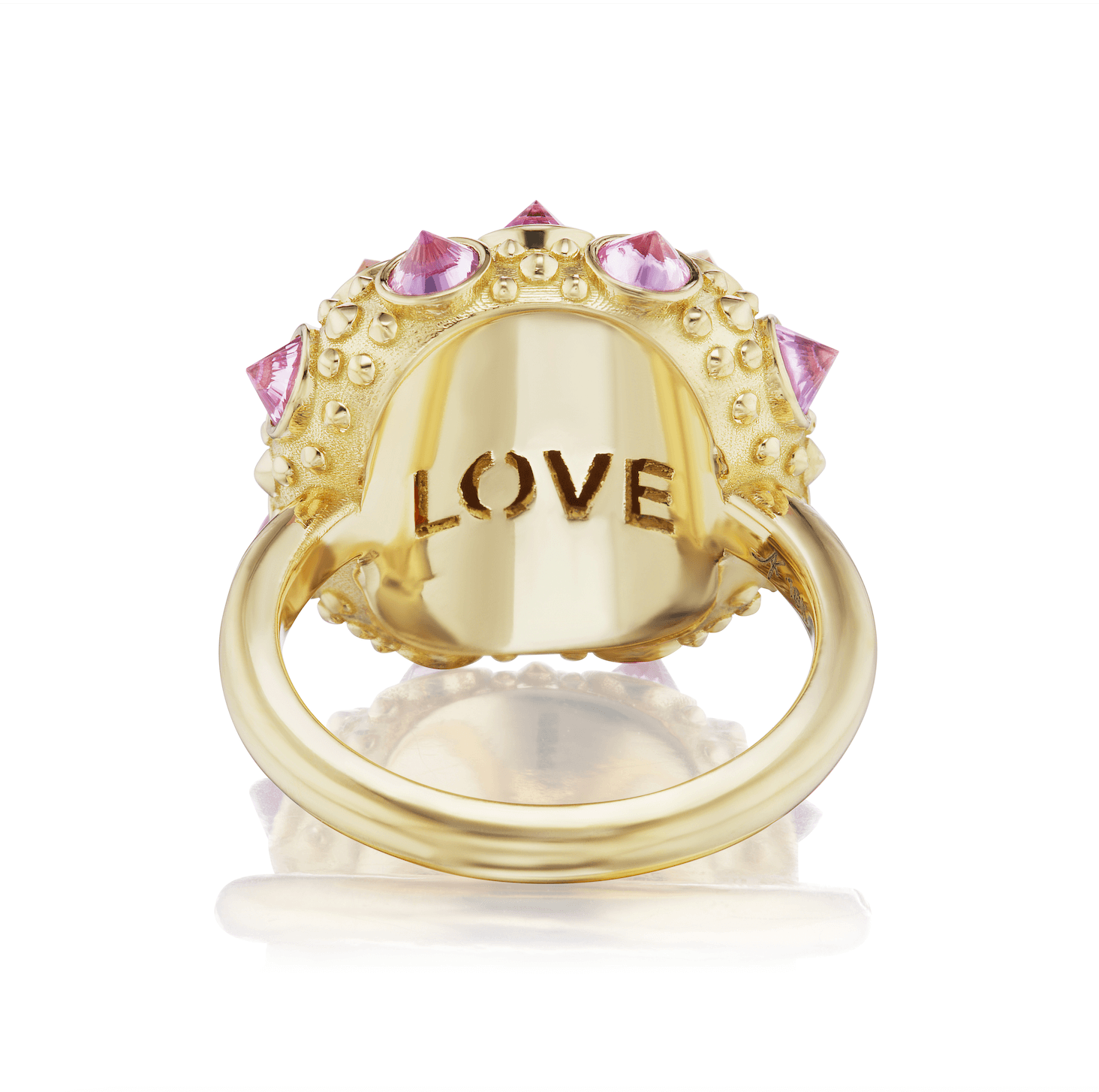 A view from the underside of an exquisite 18K yellow gold and precious gemstone ring designed by AnaKatarina Fine Jewelry. The underside of the inverted Rhodalite Garnets, Pink Sapphires, and Orange Sapphires this playfully stunning ring features the word ‘love’ carved into the 18k gold part of the ring. 