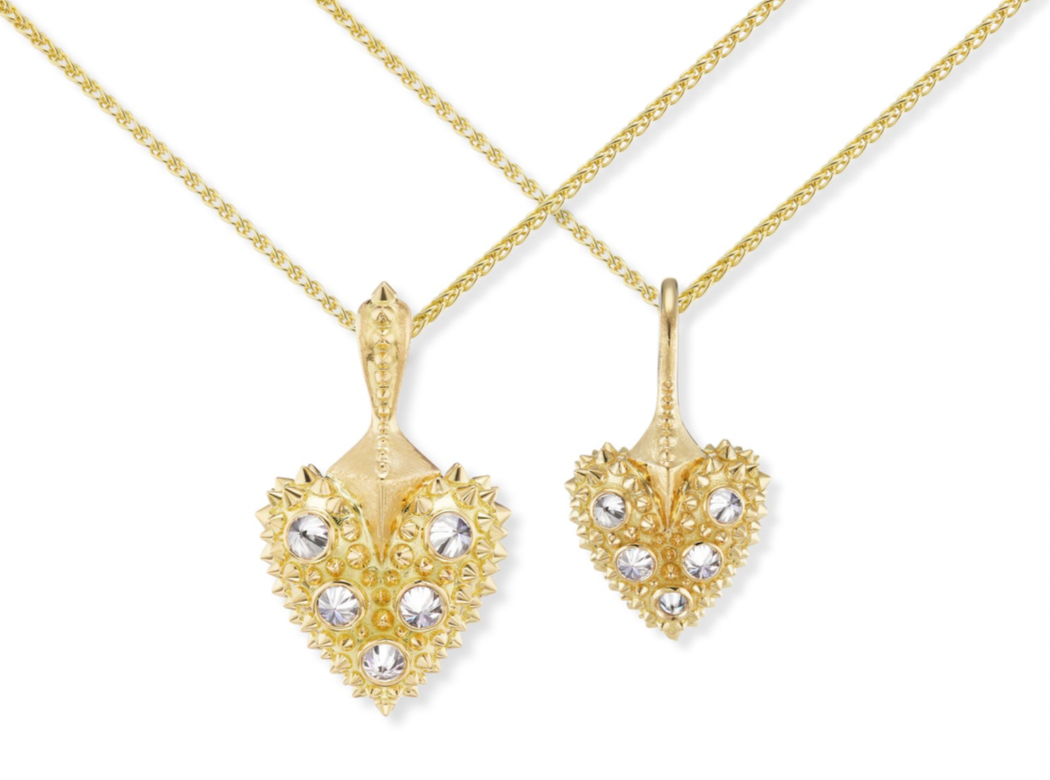 A closeup view of two 18k gold hearts with inverted diamonds & yellow gold spikes on 2mm yellow gold chains - designed by Ana-Katarina fine jewelry. 